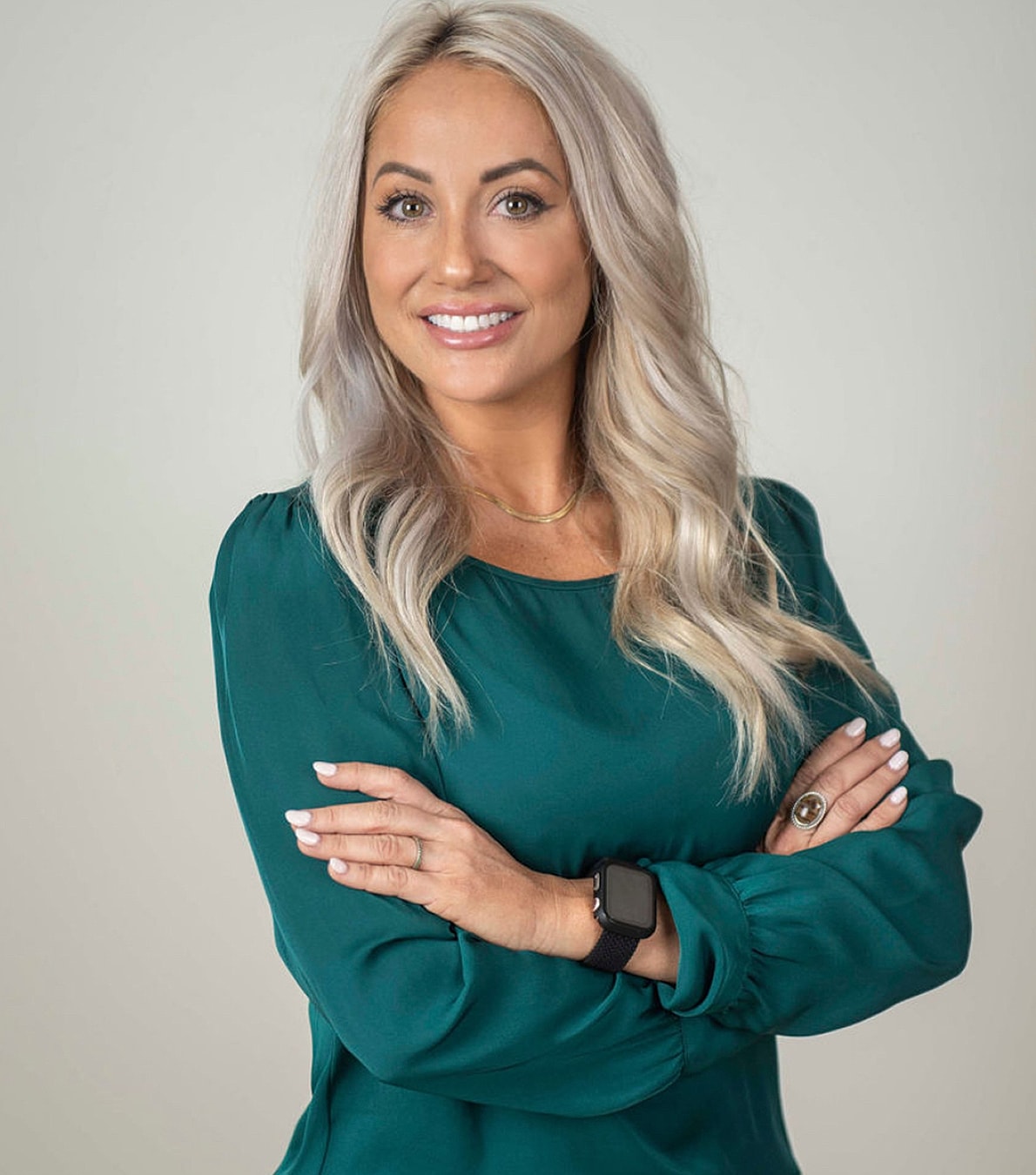Bakersfield Med Spa model in green blouse with arms crossed.