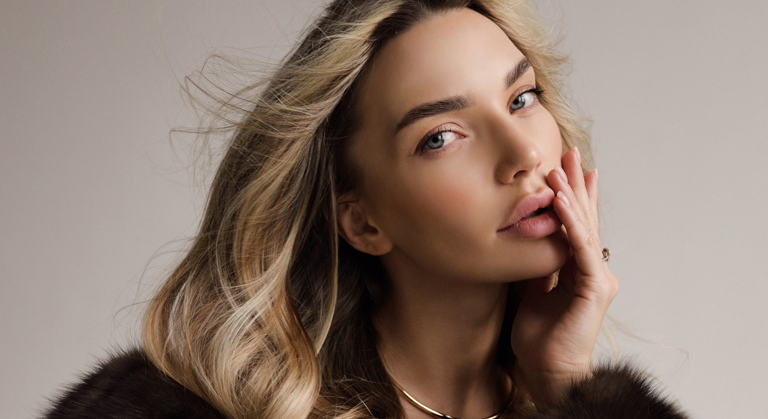 Bakersfield Lip Filler model with wavy blonde hair.