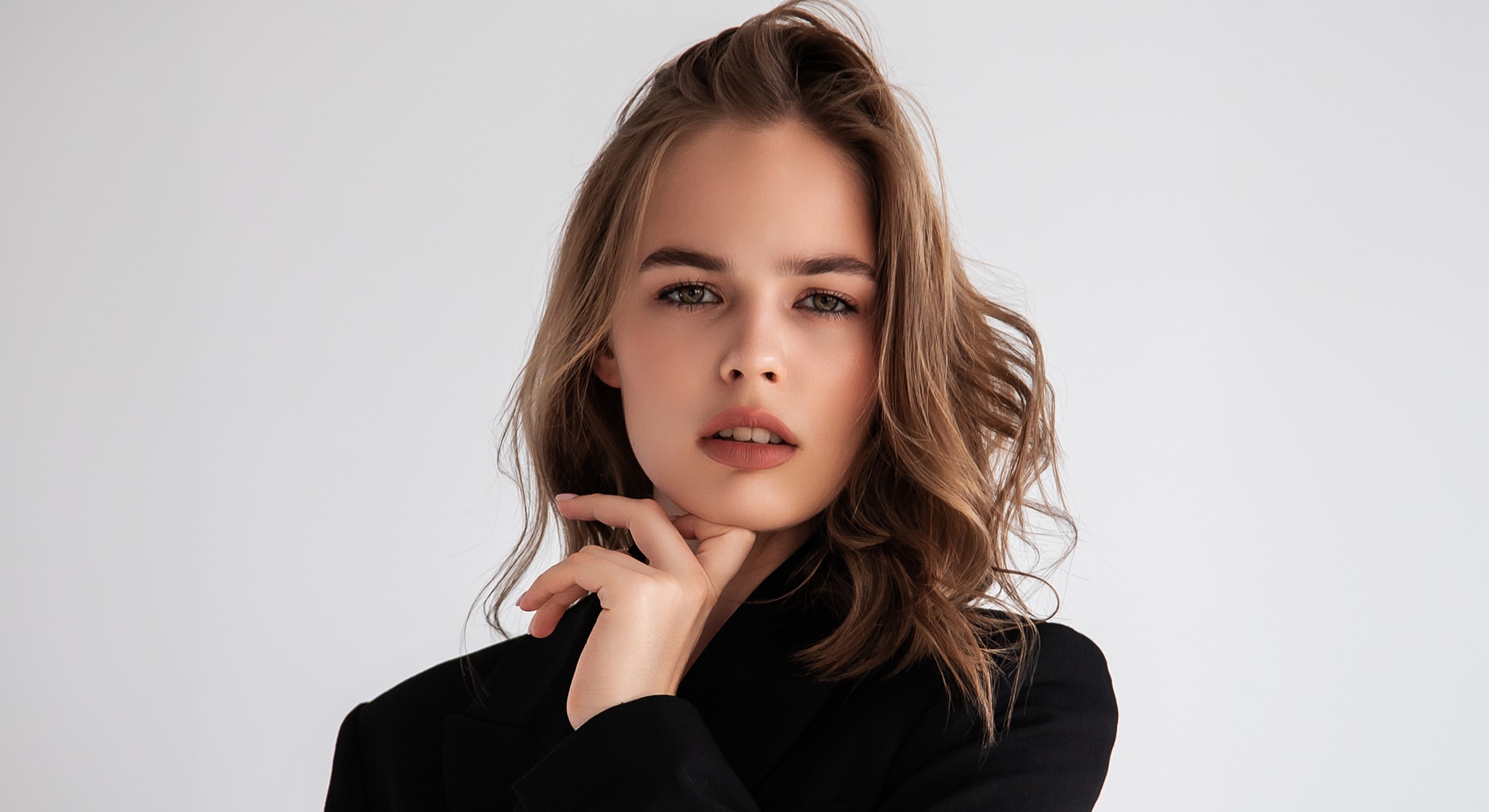 Bakersfield Facial Balancing model in black blazer with thoughtful expression.