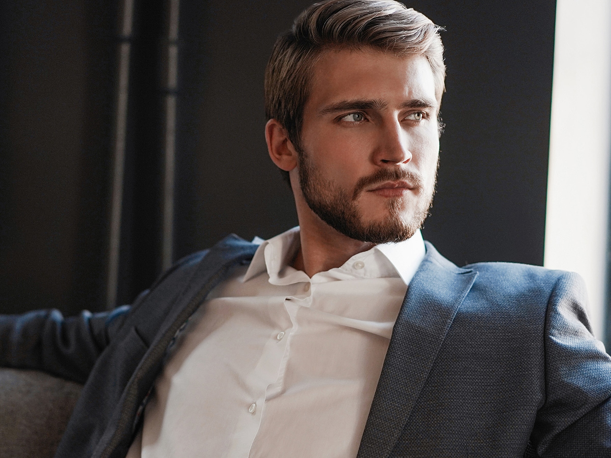 Bakersfield Med Spa model in suit contemplating thoughtfully.